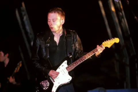 Mick Hutson / Getty Images Thom Yorke from Radiohead plays guitar