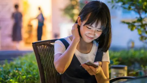 Getty Images Chinese teenager uses phone