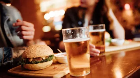 Getty Images Two people eating burgers in a pub