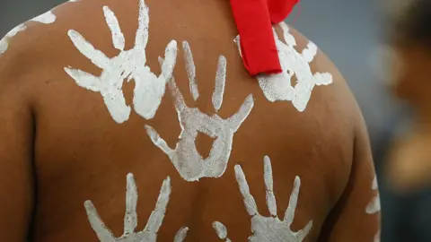 Getty Images White handprints on the back of an Aboriginal Australian performer