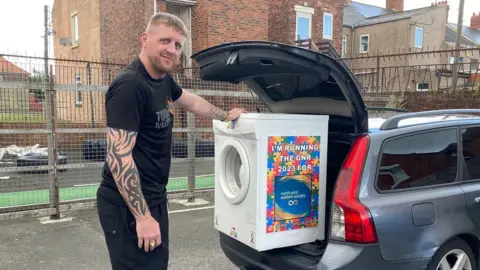 Stephen Sinclair with the tumble drier in the boot of his car