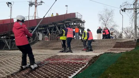 A group of skiers on a dry ski slope.