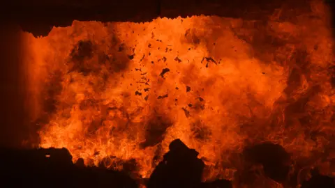 A stock photo of household waste being burned inside an incinerator.