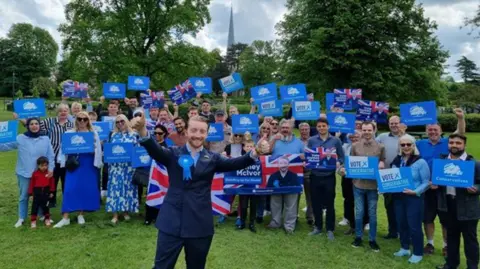 Hemel Hempstead Conservatives Jaymey McIvor standing in front of people with his thumbs up