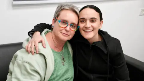 Reuters Emily (right) and her mother Mandy (left) sit with their arms around each other