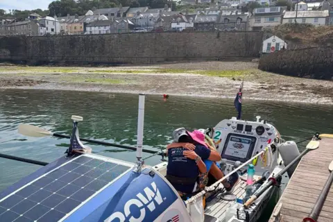 Row Aurora Two people in a docked boat embracing each other