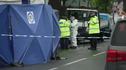 BBC Police tent in the foreground with police officers and forensics staff in the background