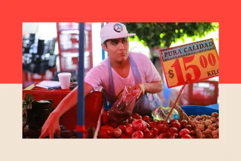 Getty Images A vendor picks avocados to sell at a market in Mexico City