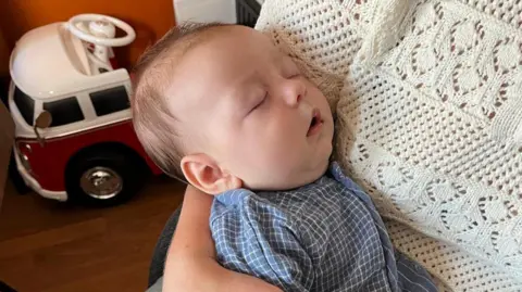 A baby in the arms of its mother.