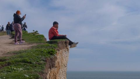 Man sitting on cliff edge in East Sussex
