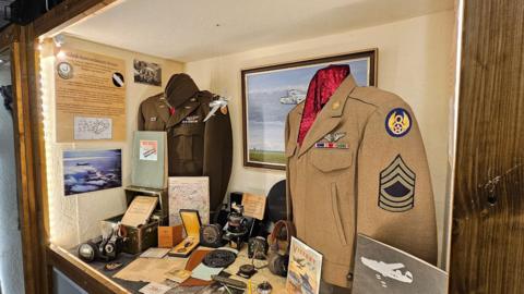 A close up of the a display showcasing uniform, medals and other artefacts from the servicemen. 