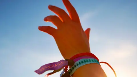 A hand in the air, with wristbands decorated around it