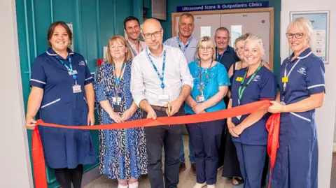 OUH Horton General Hospital staff smile as they cut the ribbon of the new improved maternity department.