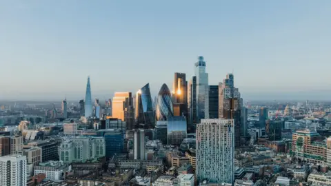 Getty Images Tall glass skyscrapers in the City of London in a panoramic view of its skyline at sunset.