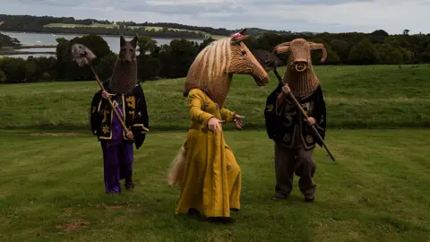 Charles McQuillan/Getty Images Three members of the Armagh Rhymers performning in a field in Castleward, County Down on September 16, 2018.  They are dressed up in their woven head pieces and period costume for a Game of Thrones-themed event. 