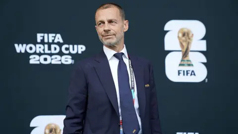 Uefa president Aleksander Ceferin in front of signage which reads Fifa World Cup 2026