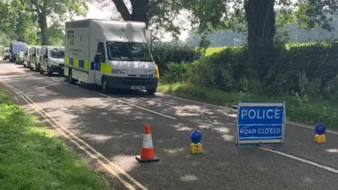 Police road-closed sign and police vehicles