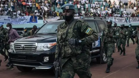 AFP The motorcade of the President of the Central African Republic, arrives at the 20,000-seat stadium, for an electoral rally, escorted by the presidential guard, Russian mercenaries, and Rwandan UN peacekeepers