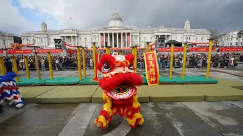 PA Media Huge crowds gather in Trafalgar square where traditional chinese celebratory performances are taking place.