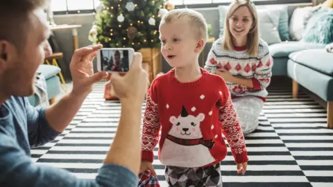 Getty Images A little boy and adult wearing Christmas jumpers