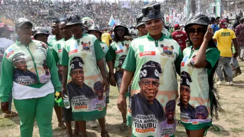 AFP Supporters wear outfits depicting a campaign poster showing presidential candidate of All Progressives Congress (APC) Bola Tinubu and runningmate Abdullahi Shettima, during a party campaign rally at Teslim Balogun Stadium in Lagos, on November 26, 2022