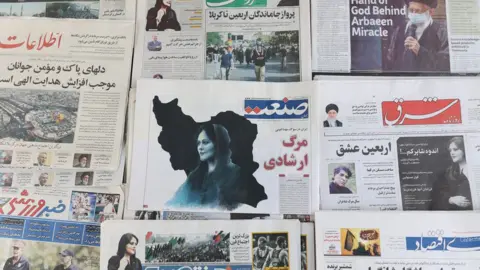 WANA NEWS AGENCY Iranian newspapers on sale in Tehran show photographs of Mahsa Amini on 18 September 2022