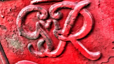 Shaun Whitmore/BBC Post box royal cypher