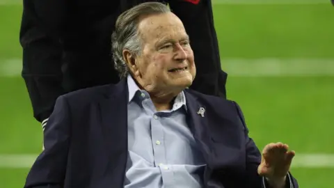 Getty Images President George H.W. Bush arrives for the coin toss prior to Super Bowl 51 between the Atlanta Falcons and the New England Patriots at NRG Stadium on February 5, 2017 in Houston, Texas