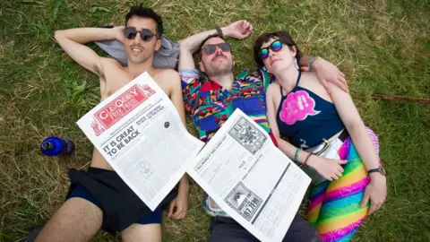 EPA-EFE/REX/Shutterstock Festival-goers enjoy the sunshine before predicted thunderstorms on the second day of the Glastonbury Festival