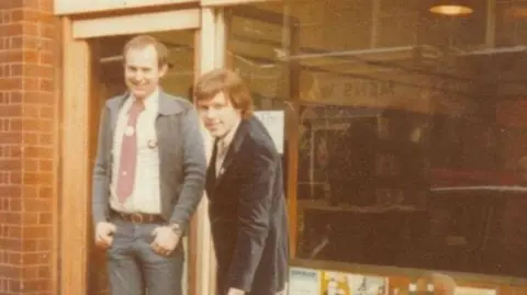 Peter is pictured on the left outside Gay’s the Word, alongside fellow bookshop founder Ernest Hole