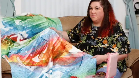 Tom Maddick/SWNS Jemma with a blanket she made as part of her masters project on child abuse