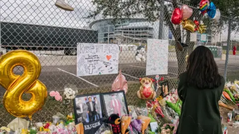 Getty Images A woman stands at a memorial outside NRG Park, where the Astroworld Festival was held.