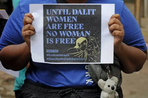 Getty Images A protester holds a placard during a demonstration against caste-based sexual violence.