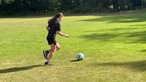Julie Lacey kicking a ball