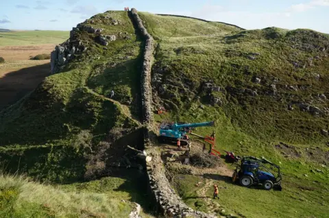 PA Media Looking down on a crane next to Hadrian's Wall