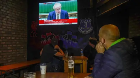 Getty Images People watch the PM in a pub in Liverpool