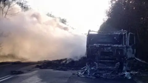 Traffic Wales The burnt remains of the lorry with smoke still visible