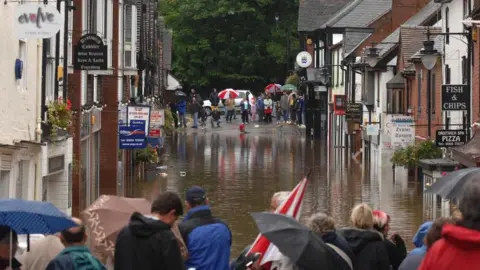 PA Media A flooded shopping street in Droitwich