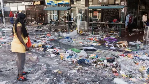 AFP Dr. Pixley Ka Seme street is strewn with dirt and filth caused after five days of looting in Durban on July 14, 2021 as several shops, businesses and infrastructure are damaged in the city, following five nights of continued violence and looting sparked by the jailing of ex-president Jacob Zuma