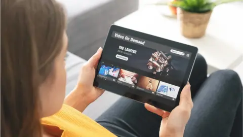 Getty Images A woman watching a streaming service on her tablet