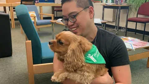 Alfred hugging a dog