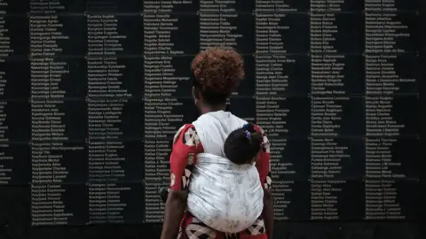 AFP Woman looking at list of Rwanda genocide victims