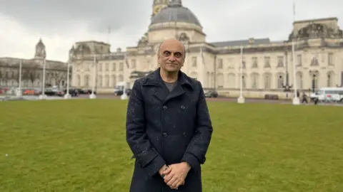 Ramesh standing in from of the Cardiff City hall