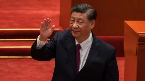 Getty Images Chinese President Xi Jinping waves after speaking during a ceremony to honour contributions to the Beijing 2022 Winter Olympics and Paralympics at the Great Hall of the People on April 8, 2022 in Beijing, China.