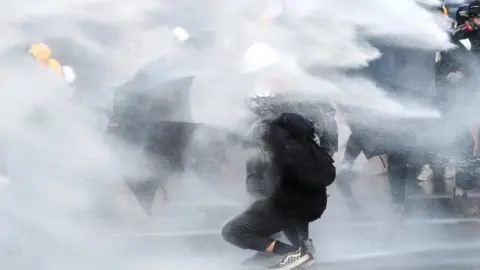 Reuters protester amid water cannon