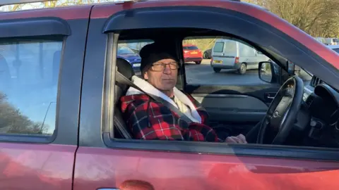 a white man in a red pick up truck