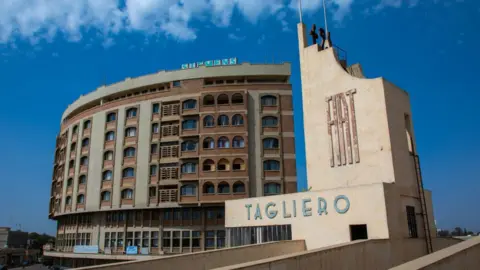Getty Images Futurist architecture of the FIAT tagliero service station built in 1938 in front of nakfa house, Central region, Asmara, Eritrea on August 22, 2019 in Asmara, Eritrea