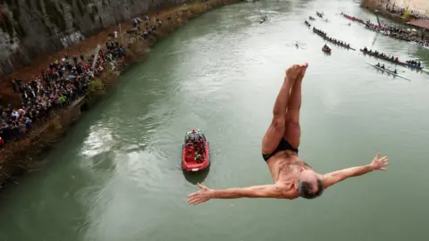 Reuters Marco Fois dives into the Tiber River from the Cavour bridge, as part of traditional New Year celebrations in Rome