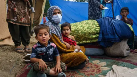 Getty Images Woman who fled fighting in Kunduz after a rocket hit her house.