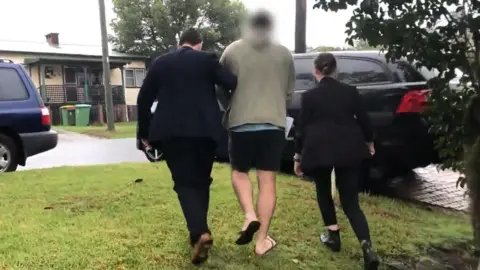 AFP Detectives escorting the 30-year-old suspect in Wyong to police car